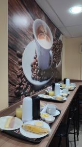 a long table with a cup of coffee and food at Hotel La Costa - Adults Only in Rio de Janeiro