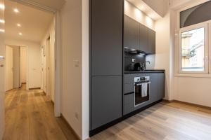 a kitchen with black cabinets and a stove at Matilde Modern apartment-Rental in Rome in Rome