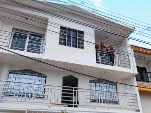 dos personas de pie en un balcón de una casa en Hermoso apartaestudio, en Pitalito