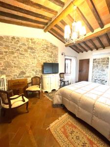 グレーヴェ・イン・キアンティにあるAppartamenti le Masseの石壁のベッドルーム1室(ベッド1台付)