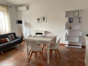 un soggiorno con tavolo e sedie bianchi di UCUPPU apartments a Carloforte