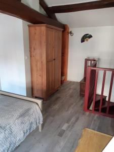 1 dormitorio con 1 cama y armario de madera en Gîte des oiseaux en Préchac