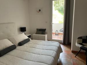 a bedroom with a bed and a large window at UCUPPU apartments in Carloforte