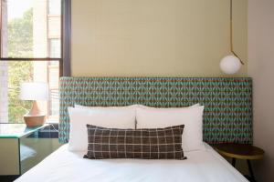 a bedroom with a bed with a green and white headboard at Hotel EPIK in San Francisco