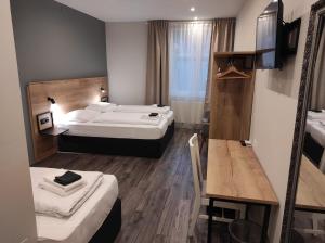 a hotel room with two beds and a table and a desk at Casablanca Boutique Bed&Breakfast in Zagreb