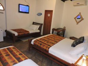 a hotel room with two beds and a tv at Hotel Puerto Gaviota in Tonsupa