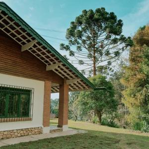 una casa de ladrillo con techo verde en Casa Wald en Campos do Jordão