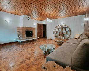 a living room with a couch and a fireplace at Casa Wald in Campos do Jordão