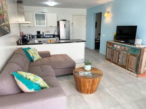 ein Wohnzimmer mit einem Sofa und einem Tisch sowie eine Küche in der Unterkunft Blue Bay Beach Apartment in Blue Bay