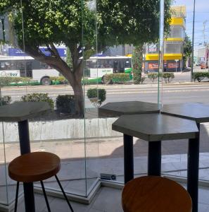 two tables and two chairs in front of a window at Hotel Estadía in León