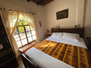 a bedroom with a bed and a large window at Hotel Puerto Gaviota in Tonsupa