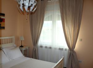 1 dormitorio con 1 cama y una ventana con cortinas en Villa Dimitri - Penthouse Seaview, en Alexandroupoli