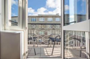 格地尼亞的住宿－Apartament Abrahama Gdynia，阳台配有椅子,享有建筑的景致。
