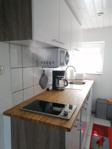 a kitchen with a wooden counter top with a microwave at Schönes Appartement " Die Ponybude" auf unserem Reiterhof in Birkenbeul