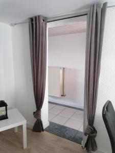 a sliding glass door with curtains in a room at Schönes Appartement " Die Ponybude" auf unserem Reiterhof in Birkenbeul