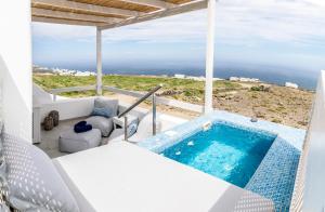 a hot tub on a balcony with the ocean in the background at Salvatore Villas in Imerovigli