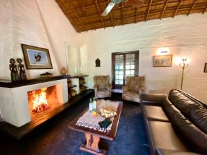 sala de estar con sofá y chimenea en Posada Morotí en Esquina