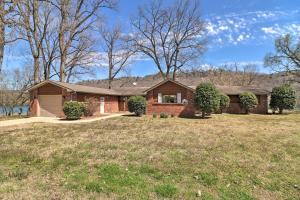 a home with a brick house with a yard at Scenic Riverview Getaway with Screened Porch! in Norfork