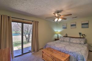 a bedroom with a bed and a ceiling fan at Scenic Riverview Getaway with Screened Porch! in Norfork
