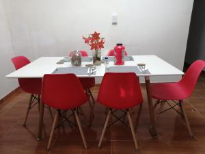 uma mesa de jantar com cadeiras vermelhas e uma mesa branca em Casa Hostal Bouvá em El Valle