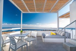 - un balcon avec un lit, une table et des chaises dans l'établissement Salvatore Villas, à Imerovigli