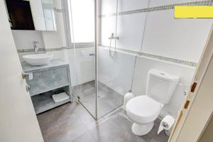 Baño blanco con aseo y lavamanos en TLV Living Apartment, en Tel Aviv