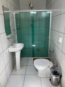 uma casa de banho com um WC, um chuveiro e um lavatório. em HOTEL QUALITY em Parauapebas