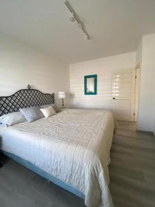 ein Schlafzimmer mit einem großen Bett in einem weißen Zimmer in der Unterkunft Great Beach Swiming Pools Tennis Courts Condo in La Paloma Rosarito Beach in Rosarito