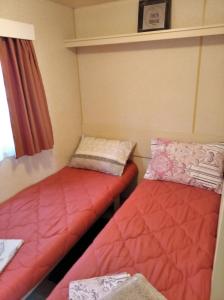 2 camas en una habitación pequeña con sábanas rojas en Anna's bella casa, en Kalamata