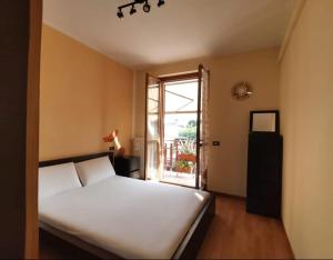- une chambre avec un lit blanc et une fenêtre dans l'établissement Casa Clusane d'Iseo 2 passi dal lago, à Clusane