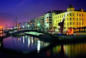 un puente sobre un río en una ciudad por la noche en Niki's apartment, en Volos