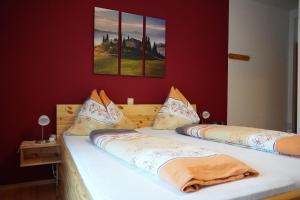 2 camas individuais num quarto com paredes vermelhas em Gästehaus Strini em Jennersdorf