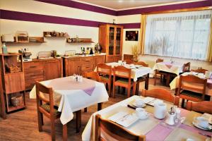 a restaurant with tables and chairs and a kitchen at Gästehaus Strini in Jennersdorf