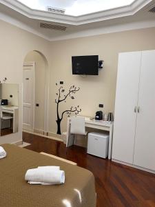 Un dormitorio con un escritorio y un televisor en la pared. en Rent rooms Saint Peter, en Roma