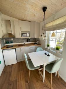 cocina con mesa de comedor blanca y sillas en Stuga smögen, en Smögen