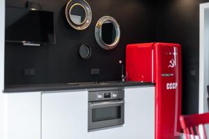 um frigorífico vermelho numa cozinha com armários brancos em Noclegi LIW APARTMENTS Hotel Apartamenty em Wegrów