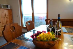 キッツィンゲンにあるWeinbergshof Rickelのワイングラス2杯付きのテーブルに盛られたフルーツボウル