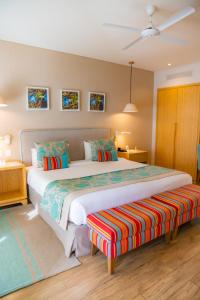 a bedroom with a large bed and a bench at Iguazu Jungle Lodge in Puerto Iguazú