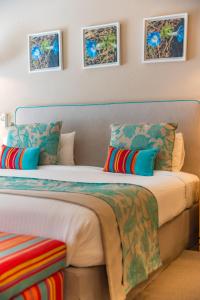 a bedroom with a large bed with colorful pillows at Iguazu Jungle Lodge in Puerto Iguazú