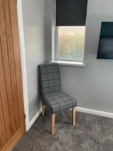 a chair sitting in a corner next to a window at Pen Mar Guest House in Tenby