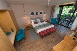 a bedroom with a king sized bed and blue chairs at Iguazu Jungle Lodge in Puerto Iguazú