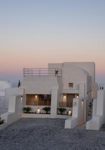 a large white building with a sunset in the background at Areos Luxury Suites in Vóthon