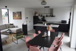 a kitchen and living room with a table and chairs at Aan Wal in Rekem