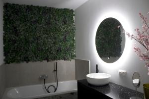 een badkamer met een bad, een wastafel en een spiegel bij Aan Wal in Rekem