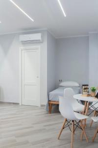 a white bedroom with a bed and a table and chairs at Albergo Libera Gioventù in Torre Annunziata