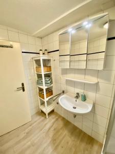 a white bathroom with a sink and a mirror at Hafenkoje Husum in Husum