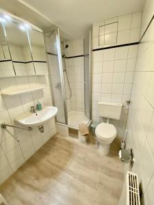 Hafenkoje Husum في هوسوم: حمام مع مرحاض ومغسلة ودش