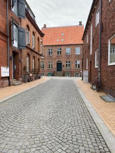 une rue pavée en face de bâtiments en briques dans l'établissement Hafenkoje Husum, à Husum