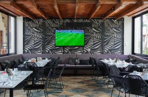 a dining room with tables and a tv on a wall at Hacienda 1800 in Cuatrociénegas de Carranza