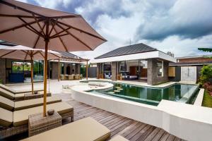 an outdoor patio with a swimming pool and a villa at Villa mon Rêve in Ubud